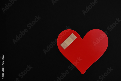 Corazón lastimado sobre fondo negro, espacio para texto al lado izquierdo. photo