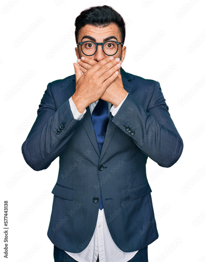 Hispanic man with beard wearing business suit and tie shocked covering mouth with hands for mistake. secret concept. Hispanic man with beard wearing business suit and tie shocked covering mouth with hands for mistake. secret concept.