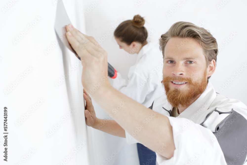 Obraz premium young builder pastering a wall