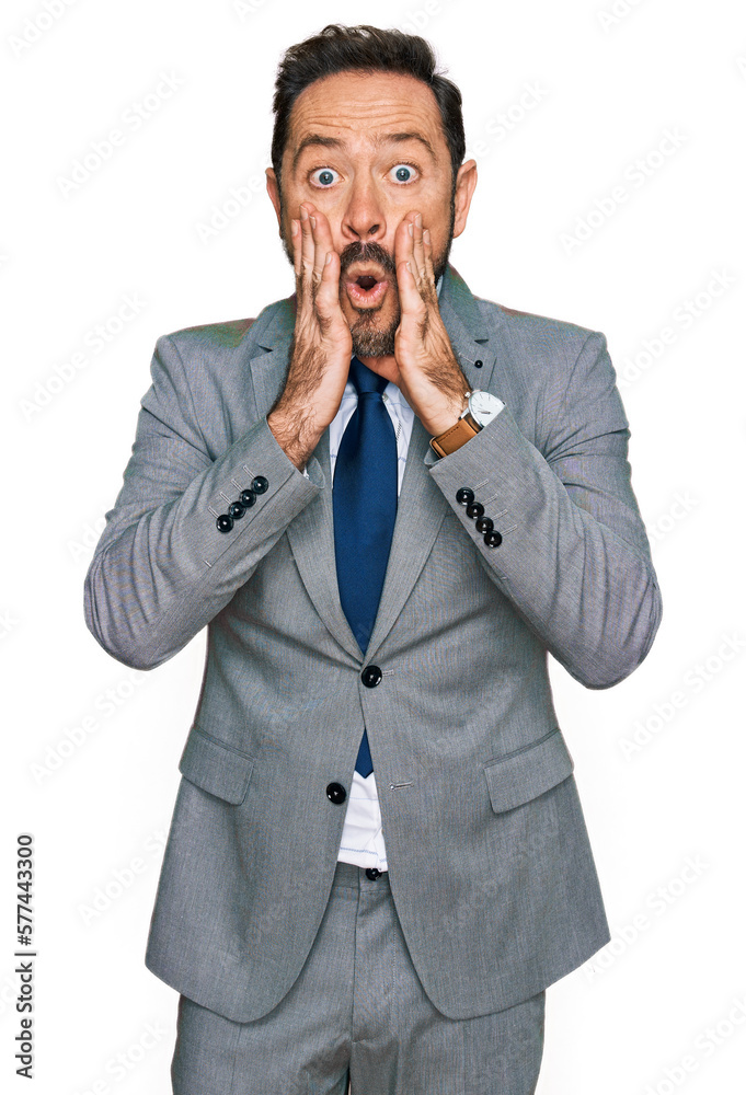 Middle age man wearing business clothes afraid and shocked, surprise and amazed expression with hands on face Middle age man wearing business clothes afraid and shocked, surprise and amazed expression with hands on face