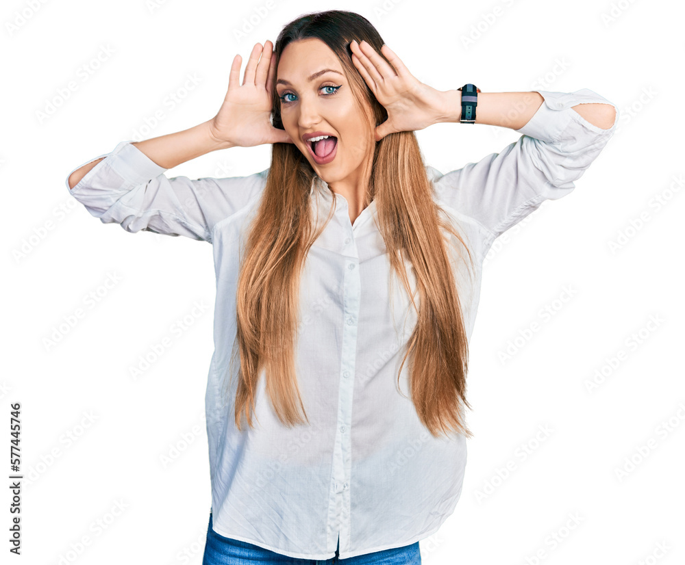 Beautiful caucasian woman wearing casual white shirt smiling cheerful playing peek a boo with hands showing face. surprised and exited Beautiful caucasian woman wearing casual white shirt smiling cheerful playing peek a boo with hands showing face. surprised and exited