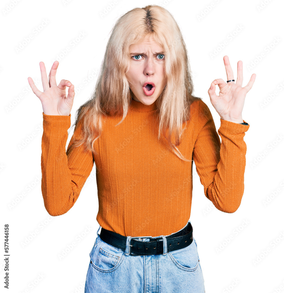 Young caucasian woman wearing casual clothes looking surprised and shocked doing ok approval symbol with fingers. crazy expression Young caucasian woman wearing casual clothes looking surprised and shocked doing ok approval symbol with fingers. crazy expression