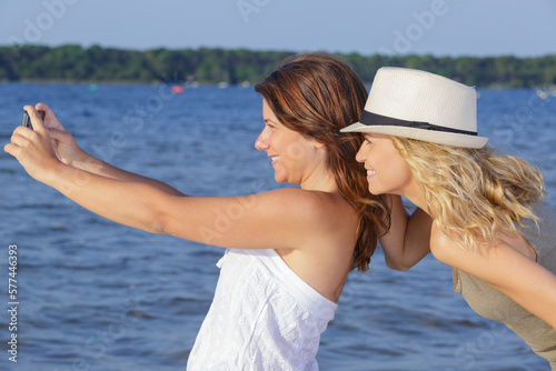 happy friends taking selfie at the coast