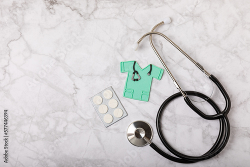National Day of Doctors. Modern stethoscope, gift box and gingerbread in the form of medical supplies on a marble background. .Gingerbread in the form of a thermometer, a medical mask, a pill, a patch photo