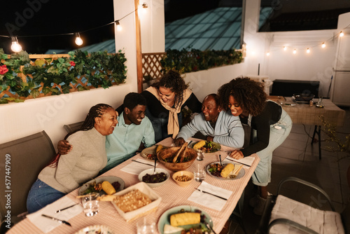 Happy African family dining together on house patio