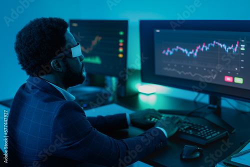 Financial analyst working on NFT blockchain technology with futuristic virtual reality glasses in office - Fintech concept