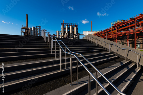Modern concrete stairway on the site of former “Kokerei Zollverein“ a majestic coking plant in Essen Ruhr Basin Germany. Tourist attraction on a sunny day with factory buildings in the background.