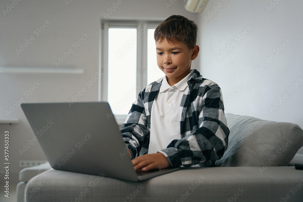 Diligent teenager on distance learning is studying on a laptop Diligent teenager on distance learning is studying on a laptop