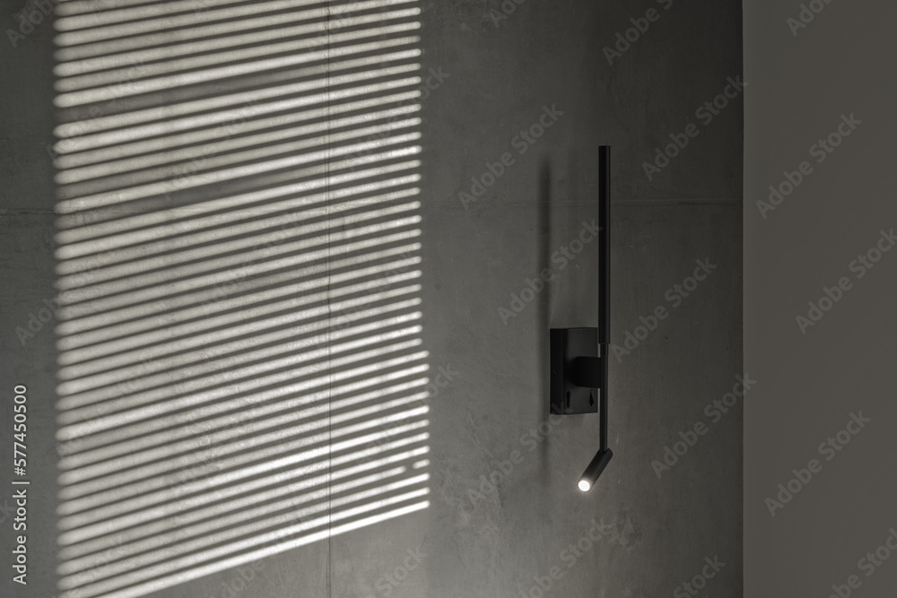 Minimalistic black wall light in modern interior in grey and black colours, concrete wall design, clay wall. Contemporary interior design aesthetics with concrete details Minimalistic black wall light in modern interior in grey and black colours, concrete wall design, clay wall. Contemporary interior design aesthetics with concrete details