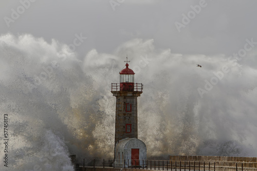 Big sea wave splash at the old lighthouse