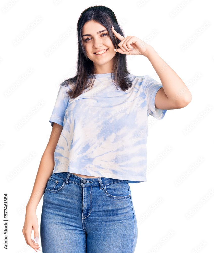 Young beautiful girl wearing casual t shirt smiling pointing to head with one finger, great idea or thought, good memory Young beautiful girl wearing casual t shirt smiling pointing to head with one finger, great idea or thought, good memory