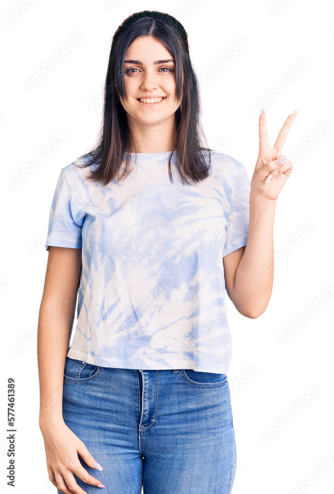 Young beautiful girl wearing casual t shirt smiling looking to the camera showing fingers doing victory sign. number two. Young beautiful girl wearing casual t shirt smiling looking to the camera showing fingers doing victory sign. number two.