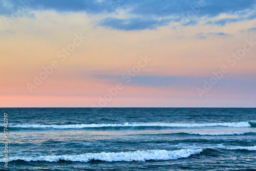 beach at sunrise with colors in the sky, coast in the background and palm tree in foreground, sayulita nayarit  © Alex Borderline