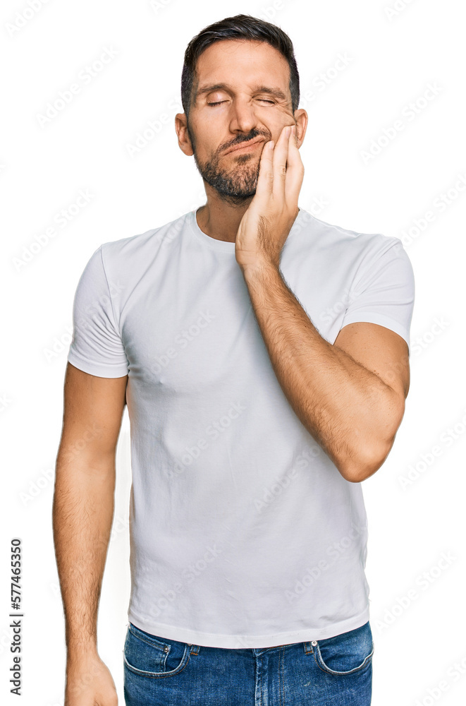 Handsome man with beard wearing casual white t shirt touching mouth with hand with painful expression because of toothache or dental illness on teeth. dentist Handsome man with beard wearing casual white t shirt touching mouth with hand with painful expression because of toothache or dental illness on teeth. dentist