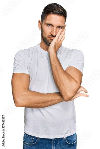 Handsome man with beard wearing casual white t shirt thinking looking tired and bored with depression problems with crossed arms.