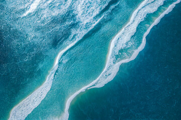 Spectacular aerial top view background photo of ocean sea water white wave splashing in the deep sea. Drone photo backdrop of sea wave in bird eye waves.