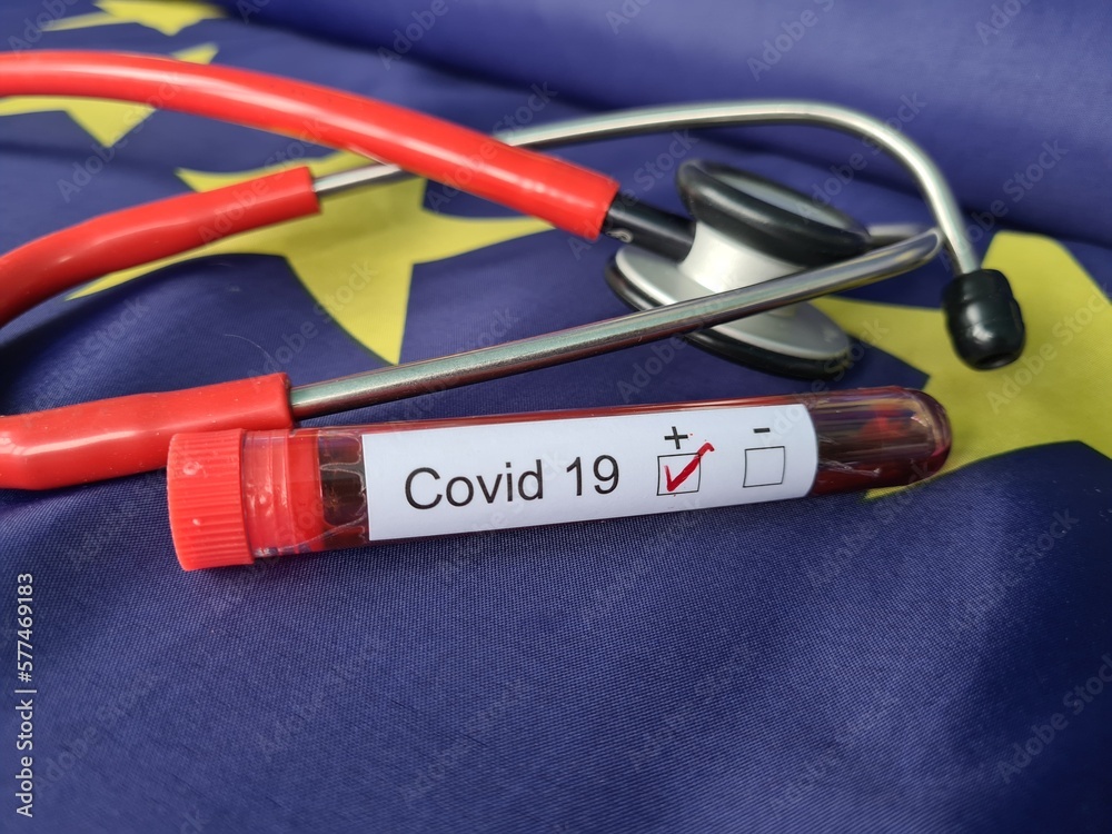 Stethoscope and test tube with positive blood sample against background of European Union flag Stethoscope and test tube with positive blood sample against background of European Union flag