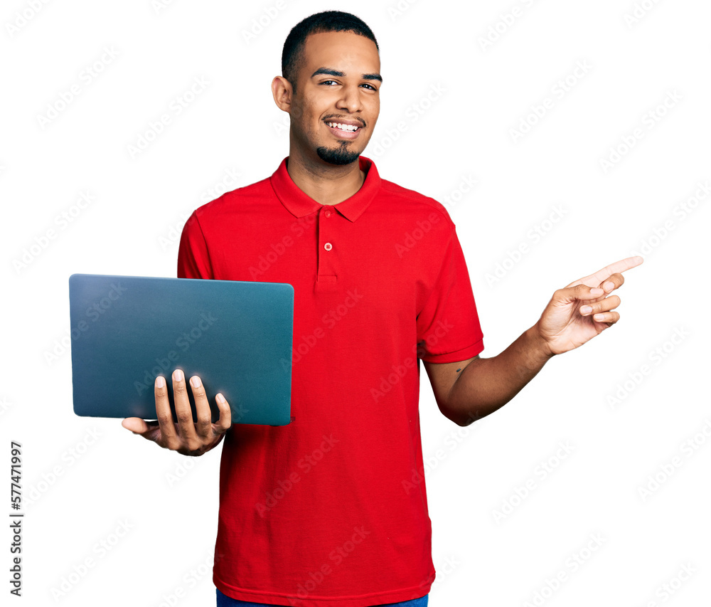 Young african american man working using computer laptop smiling happy pointing with hand and finger to the side Young african american man working using computer laptop smiling happy pointing with hand and finger to the side