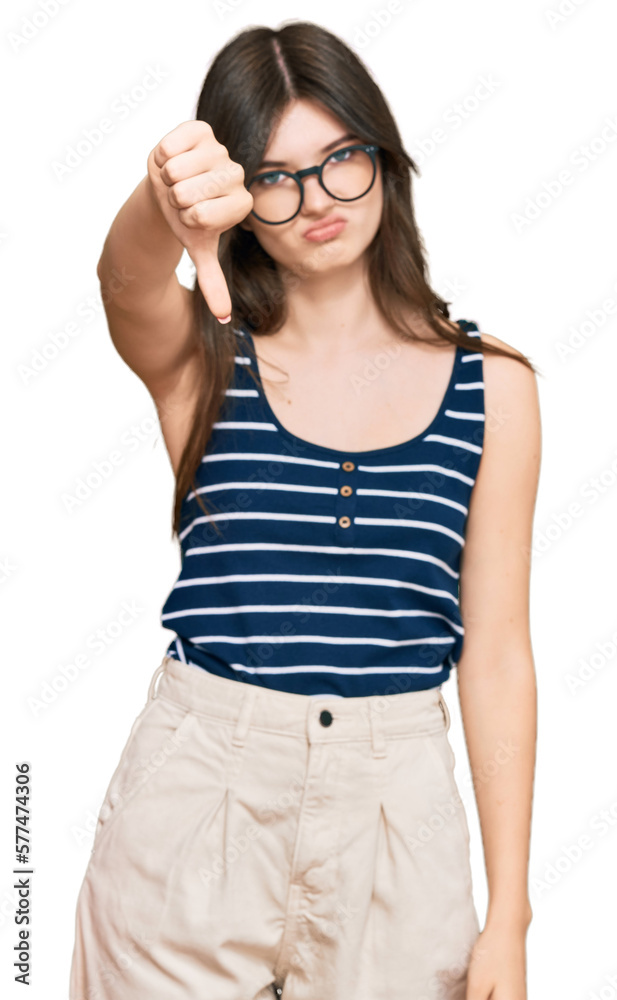 Young beautiful caucasian girl wearing casual clothes and glasses looking unhappy and angry showing rejection and negative with thumbs down gesture. bad expression. Young beautiful caucasian girl wearing casual clothes and glasses looking unhappy and angry showing rejection and negative with thumbs down gesture. bad expression.