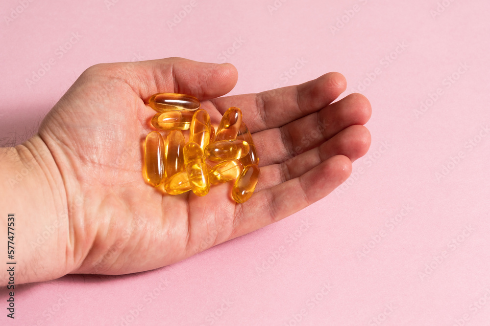 Mano sosteniendo capsulas de Omega 3 - Hand holding Omega 3 capsules Mano sosteniendo capsulas de Omega 3 - Hand holding Omega 3 capsules