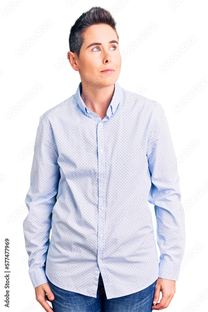 Young woman with short hair wearing business clothes smiling looking to the side and staring away thinking.