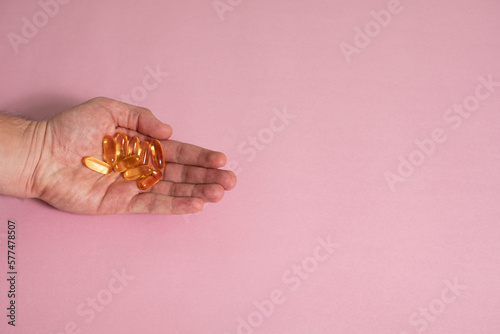 Mano sosteniendo capsulas de Omega 3 - Hand holding Omega 3 capsules