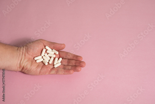 Mano sosteniendo píldoras de color blanco - Hand holding white pills