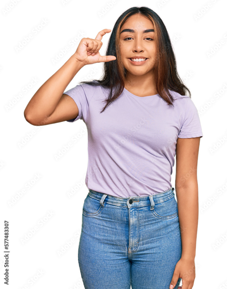 Young latin woman wearing casual clothes smiling and confident gesturing with hand doing small size sign with fingers looking and the camera. measure concept. Young latin woman wearing casual clothes smiling and confident gesturing with hand doing small size sign with fingers looking and the camera. measure concept.