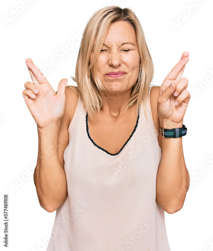 Middle age caucasian woman wearing casual clothes gesturing finger crossed smiling with hope and eyes closed. luck and superstitious concept.
