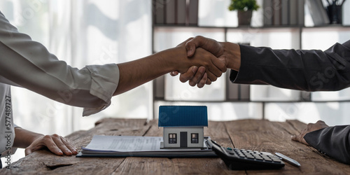 Tableau sur toile Real estate agent or realtor shakes hands with her client after making the deal in the office