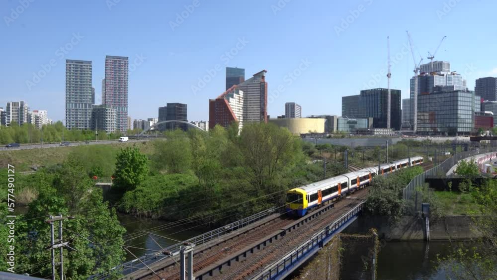 Train moving on railway track and skyline in the background in the large city on sunny day , London UK Train moving on railway track and skyline in the background in the large city on sunny day , London UK