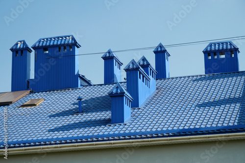 Blue roof of house with tiles and ventilation tubing photo