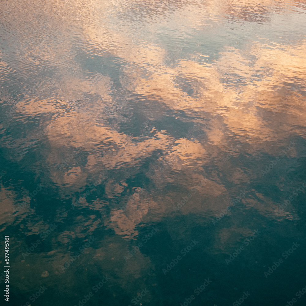 A view of sunset clouds reflecting onto the calm water