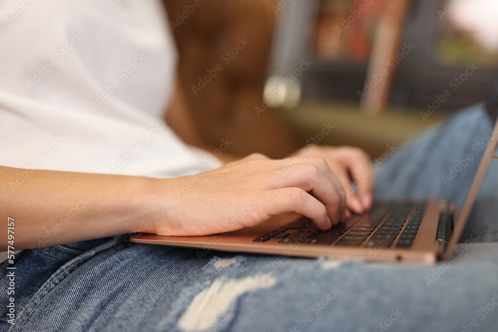 Woman sitting on sofa and working on modern laptop Woman sitting on sofa and working on modern laptop