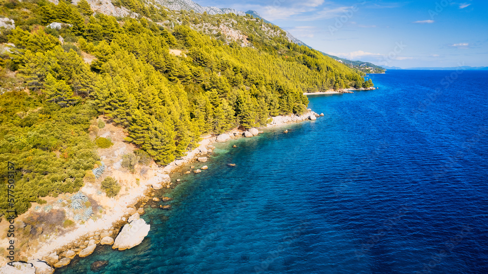 Take in the beauty of Croatia's coastal region from a new perspective with this stunning drone view, which features clear blue water and forested land.
