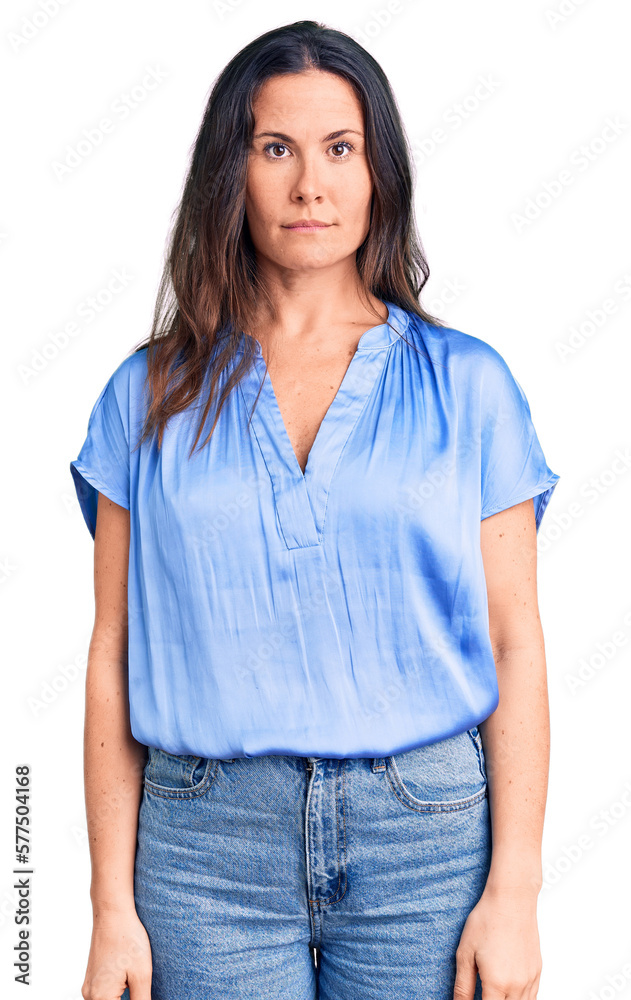 Young beautiful brunette woman wearing casual t-shirt with serious expression on face. simple and natural looking at the camera. Young beautiful brunette woman wearing casual t-shirt with serious expression on face. simple and natural looking at the camera.