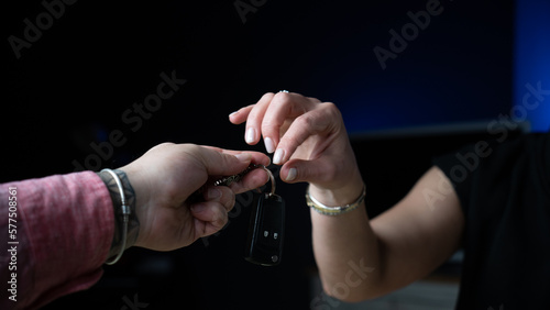 Car sale. The woman is buying a new car. Man hands woman car key