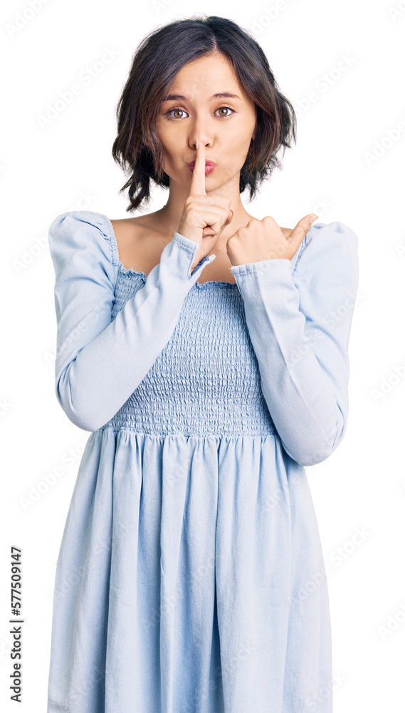 Young beautiful girl wearing casual clothes asking to be quiet with finger on lips pointing with hand to the side. silence and secret concept. Young beautiful girl wearing casual clothes asking to be quiet with finger on lips pointing with hand to the side. silence and secret concept.
