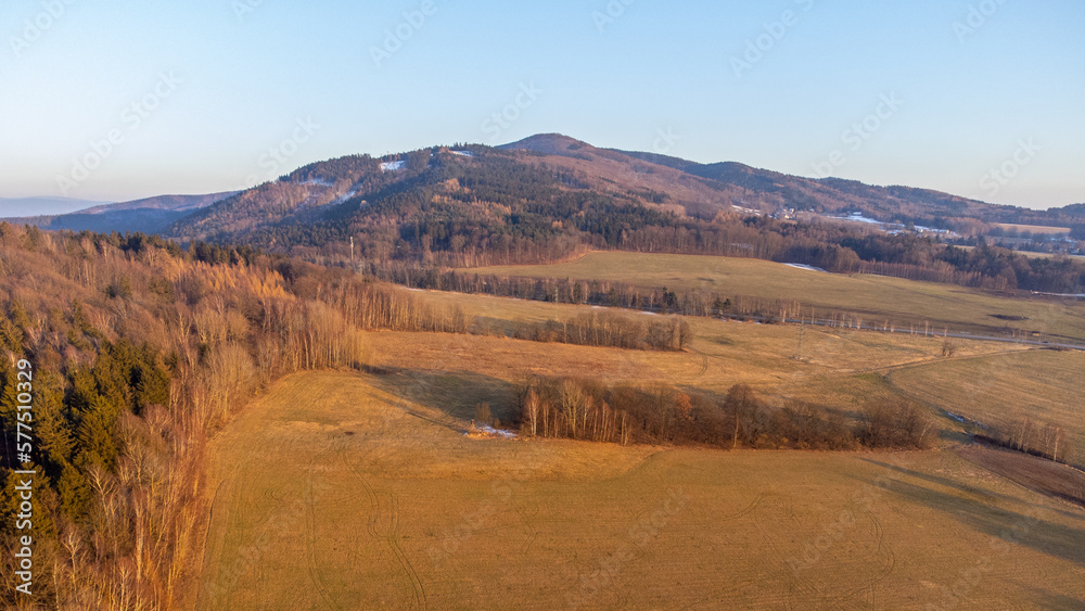 A winter landscape without snow. A clear evening during sunset over the hills of the Lusatian Mountains, Czech Republic. Aerial drone view.