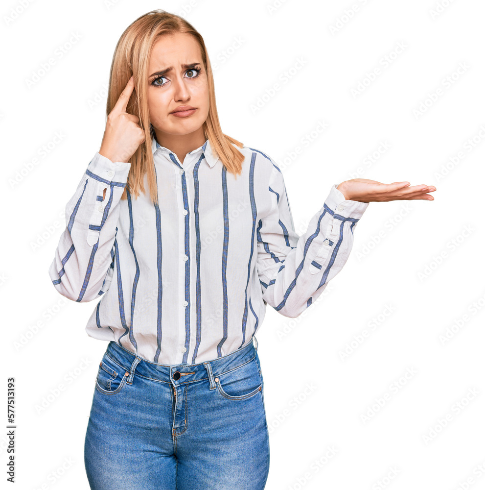 Beautiful caucasian woman wearing casual clothes confused and annoyed with open palm showing copy space and pointing finger to forehead. think about it. Beautiful caucasian woman wearing casual clothes confused and annoyed with open palm showing copy space and pointing finger to forehead. think about it.