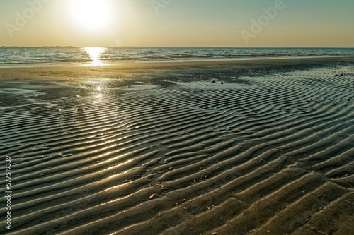 Sun setting on a rippled beach