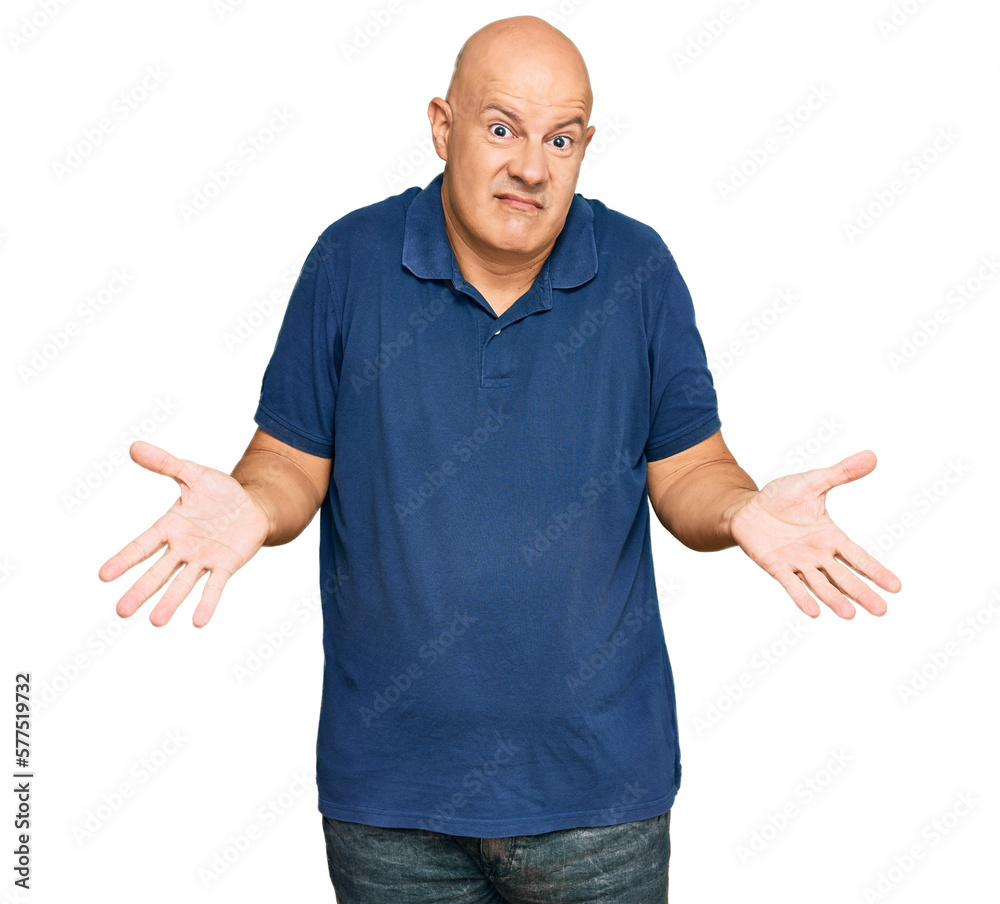 Middle age bald man wearing casual clothes clueless and confused expression with arms and hands raised. doubt concept. Middle age bald man wearing casual clothes clueless and confused expression with arms and hands raised. doubt concept.