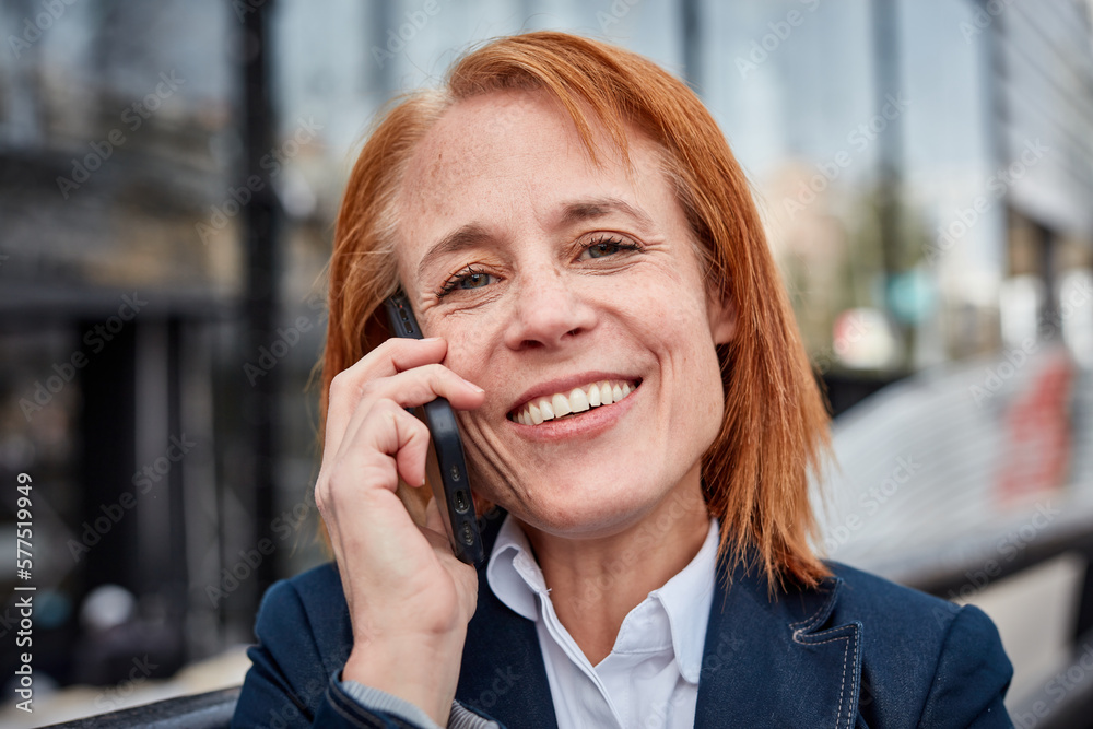 Ambitious middle-aged businesswoman, embracing unexpected challenges with a determined and professional attitude talking on mobile phone Ambitious middle-aged businesswoman, embracing unexpected challenges with a determined and professional attitude talking on mobile phone