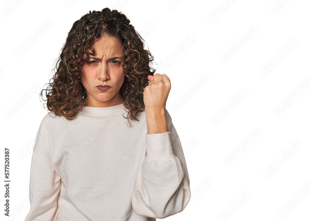 Radiant young woman with stunning curls showing fist to camera, aggressive facial expression. Radiant young woman with stunning curls showing fist to camera, aggressive facial expression.