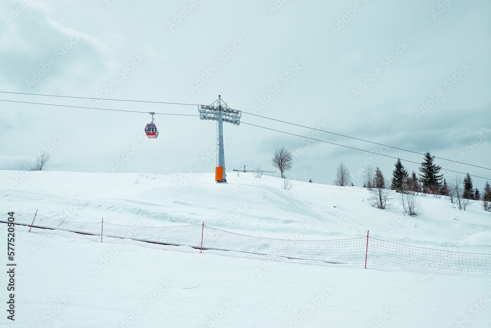 ski resort Goderdzi, Georgia. mountains are covered with snow. Red cable car above and mountains behind  - Image