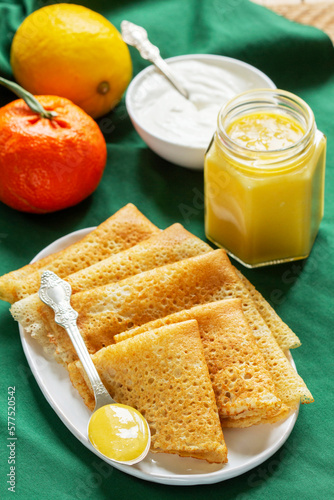 Pancakes served with fruit curd and sour cream, a traditional meal for Maslenitsa and Carnival.