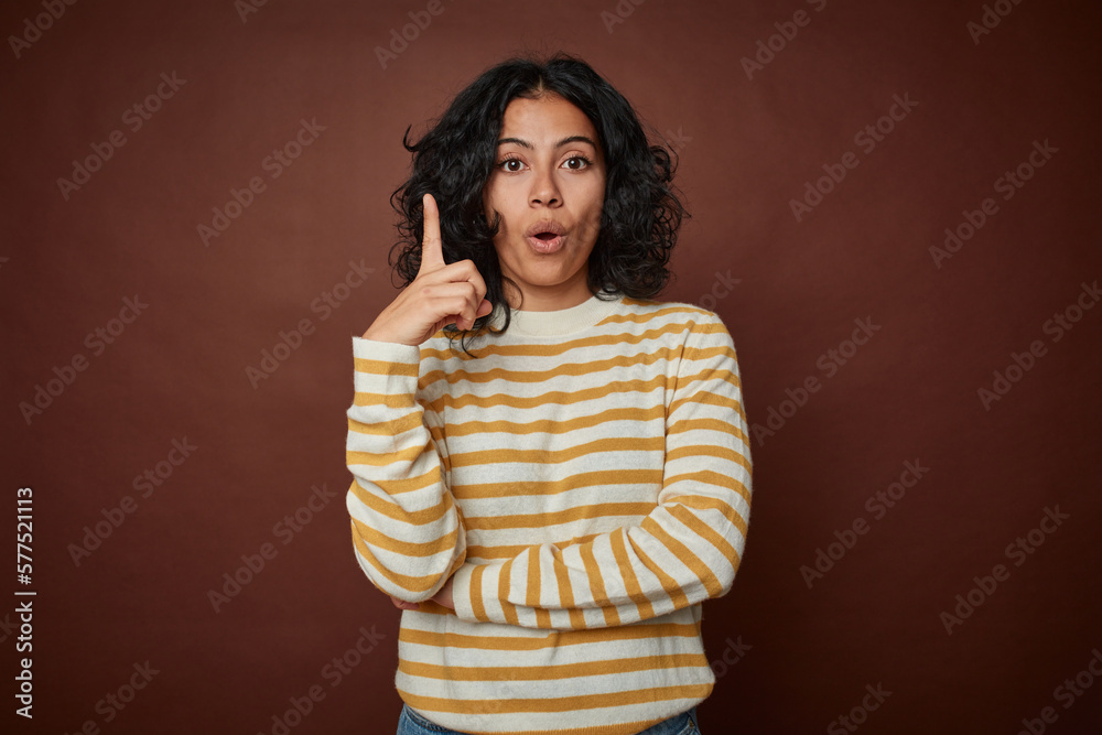 Young colombian curly hair woman isolated on brown background having some great idea, concept of creativity. Young colombian curly hair woman isolated on brown background having some great idea, concept of creativity.