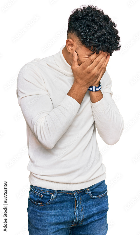 Young arab man wearing casual winter sweater with sad expression covering face with hands while crying. depression concept. Young arab man wearing casual winter sweater with sad expression covering face with hands while crying. depression concept.