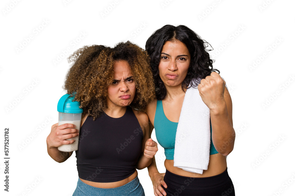 Two best friends are ready to go to the gym, one of them holds a protein shake, showing fist to camera, aggressive facial expression.