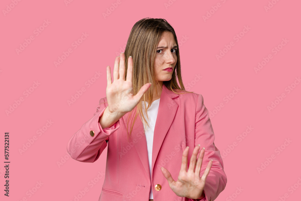Young blonde posing for a portrait isolated, exuding natural beauty and radiance standing with outstretched hand showing stop sign, preventing you. Young blonde posing for a portrait isolated, exuding natural beauty and radiance standing with outstretched hand showing stop sign, preventing you.
